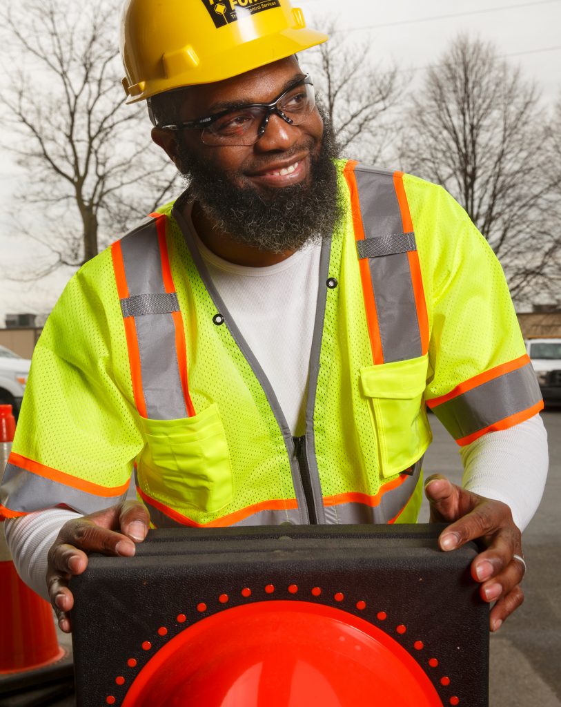 Clinton Cotton in PPE loading cones in the bed of a Flagger Force truck. 