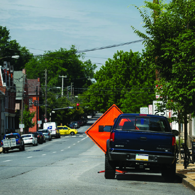 Sign being obstructed by truck in urban environment.