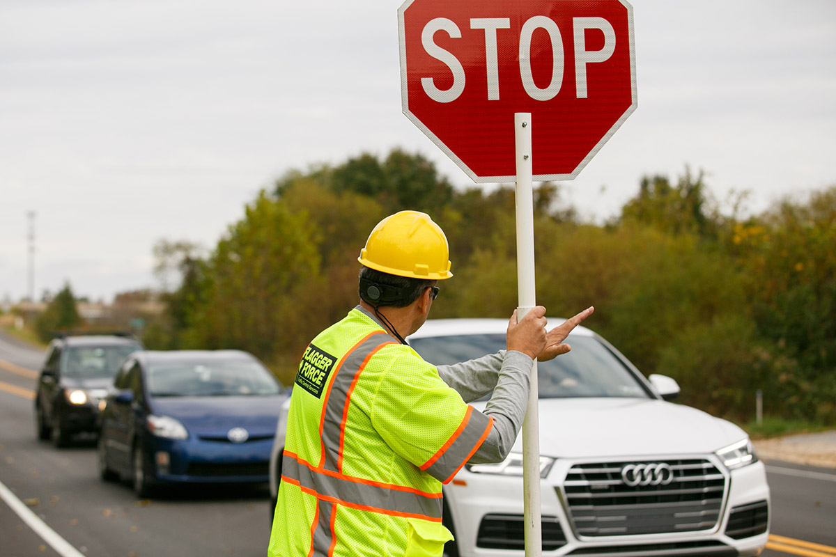 field crew employee flagging cars to slow down