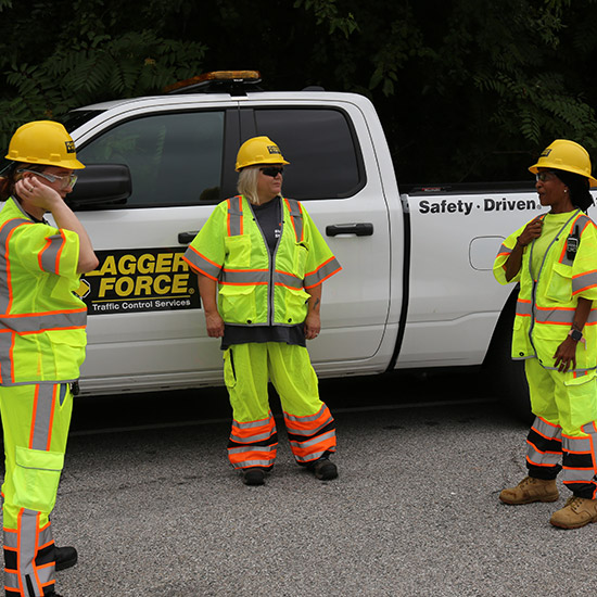 team-of-three-field-employees-discussing-job-by-a-truc