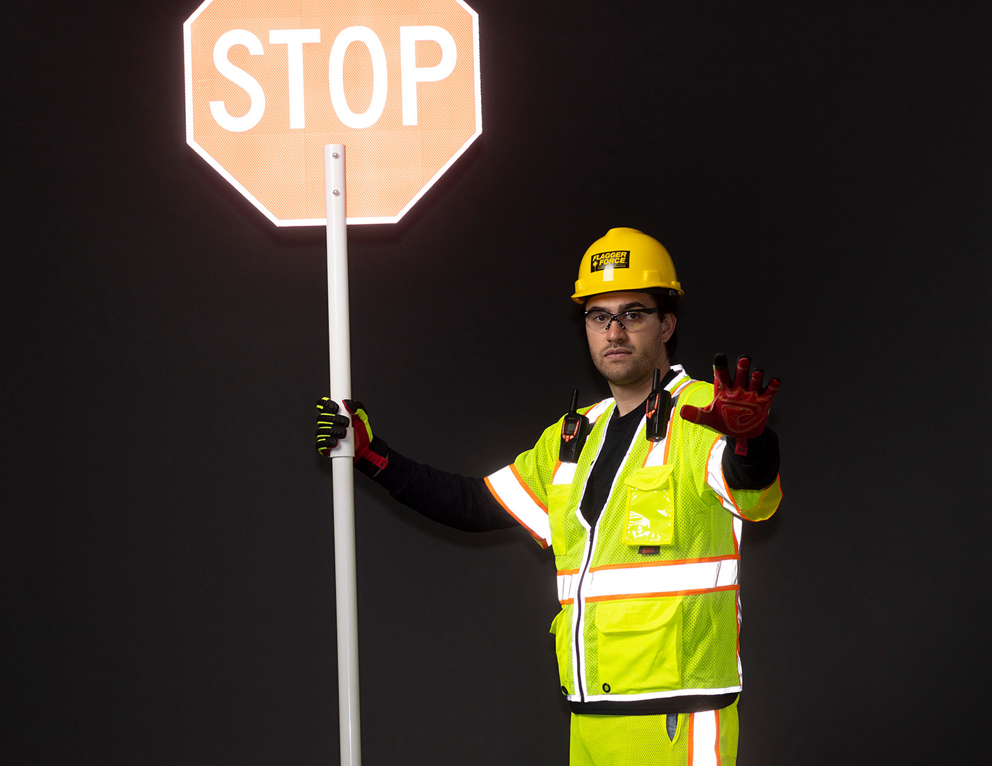 worker-with-high-visibility-gear-holding-a-stop-sign