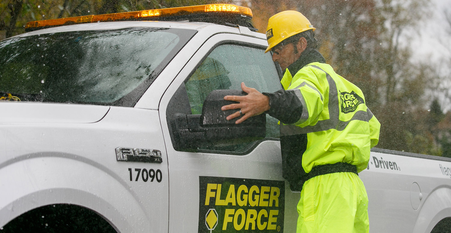 Field crew member exiting truck in the rain