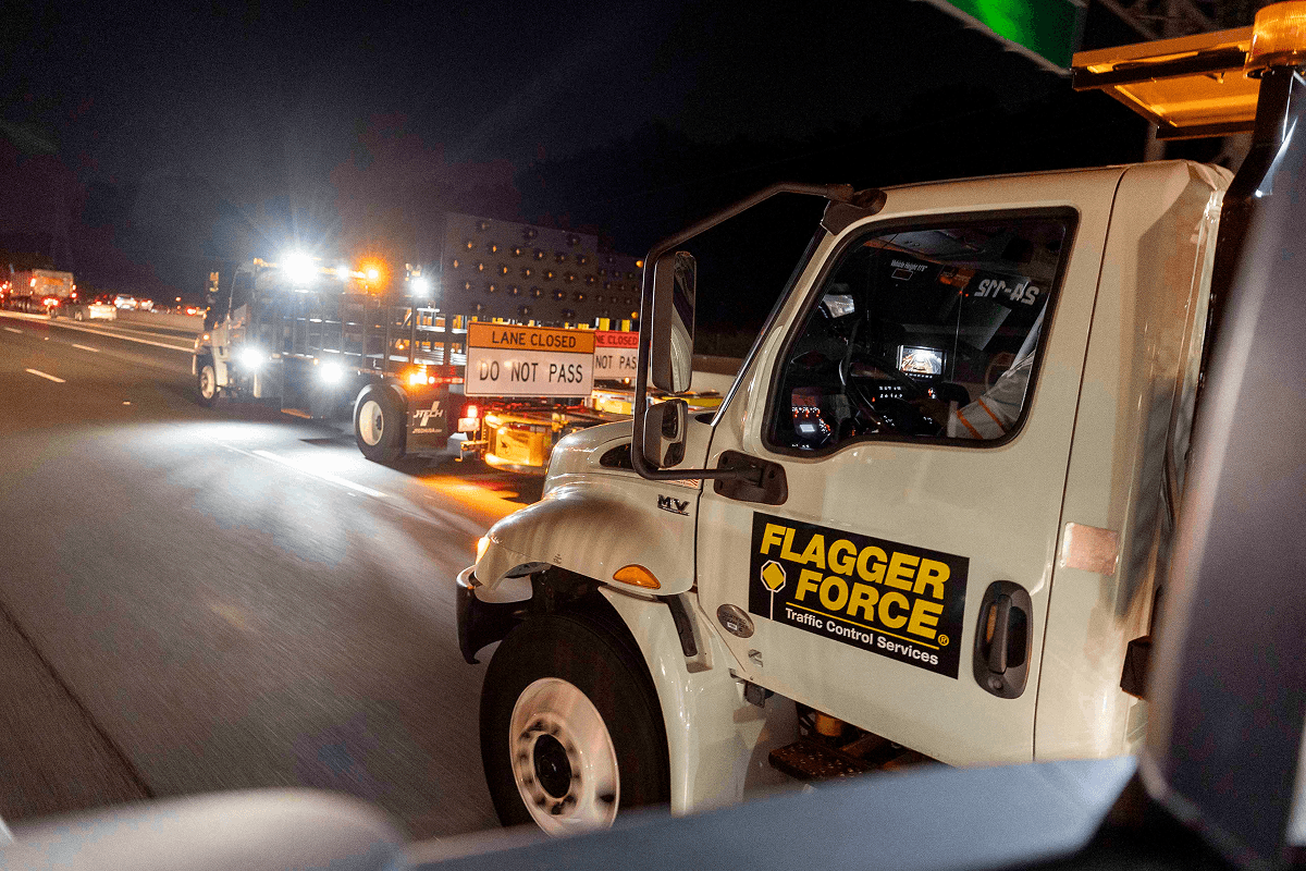 Flagger Force vehicles on highway placing lane closed signage