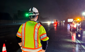 INDOT employee wearing flashing green light on hard hat. 